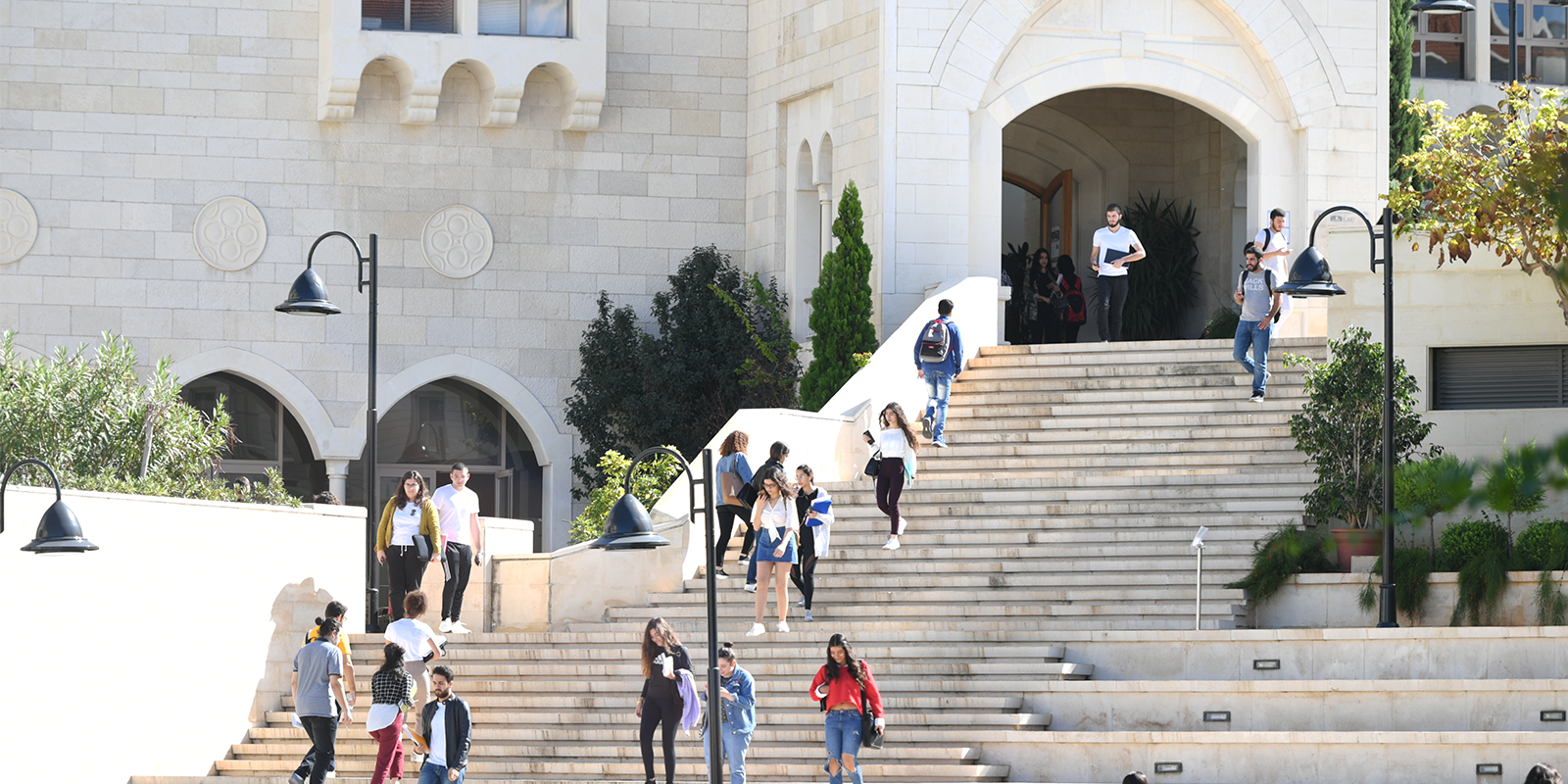 students walking down stairs to university building